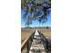 Scenic marsh view with a wooden boardwalk leading to waterfront homes and moss-draped trees under a bright blue sky at 185 5Th Ave, Mount Pleasant, SC 29464