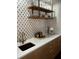 Close-up shot of a bar area featuring a countertop, decorative backsplash, modern sink, faucet, and shelving at 2014 Ion Ave, Sullivans Island, SC 29482