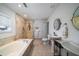 Bright bathroom boasts dual sinks, a soaking tub, and a walk-in shower with modern fixtures at 2014 Ion Ave, Sullivans Island, SC 29482