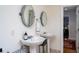 Bathroom with two pedestal sinks, round mirrors, and tiled floors near the doorway at 2014 Ion Ave, Sullivans Island, SC 29482