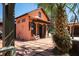 Charming exterior view of guesthouse with a rocking chair on a brick patio with mature landscaping at 2014 Ion Ave, Sullivans Island, SC 29482