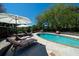 Relaxing poolside view with comfortable lounge chairs, umbrellas, and a refreshing in-ground swimming pool surrounded by greenery at 2014 Ion Ave, Sullivans Island, SC 29482
