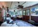 This sunroom has natural lighting, hardwood floors, a ceiling fan, and comfortable seating at 2014 Ion Ave, Sullivans Island, SC 29482