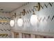 Interior wall featuring globe sconces with brass hardware and chevron-patterned wallpaper, creating an elegant lighting design at 2014 Ion Ave, Sullivans Island, SC 29482