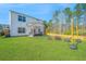 Spacious backyard with lush green lawn and outdoor fire pit area with seating and a covered patio at 204 Torslanda Ln, Summerville, SC 29486