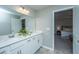 Well-lit bathroom featuring a double sink vanity with white cabinets and a glimpse into a Primary bedroom at 204 Torslanda Ln, Summerville, SC 29486