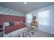 Stylized bedroom featuring a pink accent wall and bed, complemented by a vanity desk and natural light at 204 Torslanda Ln, Summerville, SC 29486