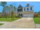Charming two-story home with a well-manicured lawn and a two-car garage with a beautiful blue sky overhead at 204 Torslanda Ln, Summerville, SC 29486