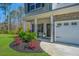 Inviting front porch with decorative plants, rocking chairs, and stone accents on a two-story home at 204 Torslanda Ln, Summerville, SC 29486