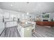 Open-concept kitchen with a central island, stainless steel appliances, and seamless flow to the living room at 204 Torslanda Ln, Summerville, SC 29486