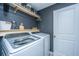 Functional laundry room with new machines, overhead shelving, and stylish wall paneling; great for organization at 204 Torslanda Ln, Summerville, SC 29486