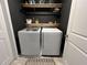 Modern laundry room with sleek, front-loading washer and dryer and contemporary black shelving at 204 Torslanda Ln, Summerville, SC 29486