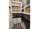 Well-organized walk-in pantry with wood counter, tile backsplash, shelves, baskets, and bulk food dispensers at 204 Torslanda Ln, Summerville, SC 29486