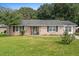 Quaint brick home with a green lawn, decorative shutters, and a welcoming entrance at 208 James St, Summerville, SC 29483