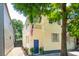 Charming yellow home featuring a blue door and an American flag, nestled under lush green trees at 21 America St, Charleston, SC 29403