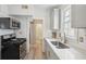 Well-lit kitchen with gray cabinets, stainless steel appliances, and a view into the bathroom at 21 America St, Charleston, SC 29403