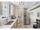 Updated kitchen featuring gray cabinets, stainless steel appliances, and a view into the laundry area at 21 America St, Charleston, SC 29403