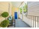 Inviting front porch with a bench, lush greenery, and a blue front door at 21 America St, Charleston, SC 29403