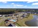 Aerial view of a neighborhood pool and playground near a pond with new construction at 211 Saxony Loop, Summerville, SC 29486