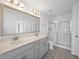 Bathroom features double sink vanity, framed mirror, and glass enclosed shower at 211 Saxony Loop, Summerville, SC 29486