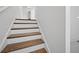 Wood-capped staircase featuring white risers ascending to the next level of the home at 211 Saxony Loop, Summerville, SC 29486