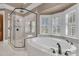 Bright bathroom showcasing a luxurious soaking tub, frameless glass shower, and plantation shutters at 2292 Beckenham Dr, Mount Pleasant, SC 29466