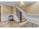 Staircase in foyer with wooden steps, black iron railing, neutral walls, and decorative tile flooring at 2292 Beckenham Dr, Mount Pleasant, SC 29466