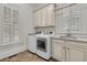 The laundry room features a washer, dryer, custom cabinets, a sink, and shuttered windows at 2292 Beckenham Dr, Mount Pleasant, SC 29466
