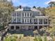Expansive rear exterior featuring a large deck, covered porch, and lush surroundings at 2292 Beckenham Dr, Mount Pleasant, SC 29466