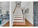 Bright foyer features hardwood floors, staircase with white risers and wooden handrail, flowing into a cozy living space at 235 Scalybark Rd, Summerville, SC 29485