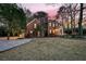 Elegant brick home with a charming covered entry, complemented by a green lawn and mature trees at 235 Scalybark Rd, Summerville, SC 29485
