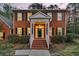 Inviting brick home entrance with white columned porch, manicured bushes and brick steps at 235 Scalybark Rd, Summerville, SC 29485