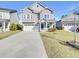 Charming two-story home featuring a blue front door, well-manicured lawn, and attached two-car garage at 253 Palmetto Walk Dr, Summerville, SC 29486