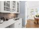 Butler's pantry with sink, marble countertop, glass-door cabinets, and hardwood floors at 2912 Yachtsman Dr, Mount Pleasant, SC 29466