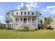 Elegant two-story home boasting a covered front porch, white railing, and beautifully landscaped yard at 2912 Yachtsman Dr, Mount Pleasant, SC 29466
