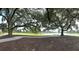 Scenic view of lush landscaping, mature trees, and serene waterfront with inviting seating on a sunny day at 2912 Yachtsman Dr, Mount Pleasant, SC 29466