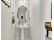 A cozy powder room featuring pedestal sink, oval mirror and neutral decor at 303 Pine Bluff Dr, Summerville, SC 29483