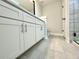 Modern bathroom featuring dual sinks, quartz countertops, and tile flooring at 310 Woodland Shores Rd, Charleston, SC 29412