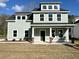 Charming two-story home featuring a covered porch with craftsman style columns and a well-manicured lawn at 310 Woodland Shores Rd, Charleston, SC 29412