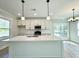 Bright kitchen featuring a spacious island, modern appliances, white cabinetry, and a stylish subway tile backsplash at 310 Woodland Shores Rd, Charleston, SC 29412