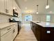 Well-lit kitchen featuring an island with sink, stainless steel appliances and white and dark cabinets at 310 Woodland Shores Rd, Charleston, SC 29412