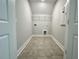 Functional laundry room with tiled floors, wire shelving, and utility connections offers convenience and organization at 310 Woodland Shores Rd, Charleston, SC 29412