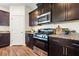 Kitchen boasts stainless steel appliances, granite counters, and dark cabinetry for a modern look at 342 Saxony Loop, Summerville, SC 29486