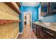 Stylish pantry with blue walls, decorative wallpaper, wooden shelves, granite counters, and dark cabinets at 342 Saxony Loop, Summerville, SC 29486