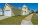 Exterior view of yellow house and garage with a sidewalk and grass at 401 Forsythia Ave, Summerville, SC 29483