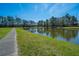 Scenic pond surrounded by lush greenery and a paved walking path, offering a serene outdoor space at 401 Forsythia Ave, Summerville, SC 29483