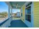 View of a porch with white railings and columns, blue ceiling, and view of street at 401 Forsythia Ave, Summerville, SC 29483