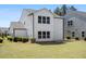 View of the backyard showing lawn, shrubs, and the rear of the house with neutral vinyl siding at 410 Avocet Dr, Summerville, SC 29486