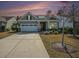 Charming home featuring a two-car garage, well-manicured lawn, and cozy front porch, basking in a colorful sunset at 415 Four Seasons Blvd, Summerville, SC 29486