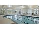 Indoor community pool with lap lanes, tiled floors and walls, and plenty of natural light at 415 Four Seasons Blvd, Summerville, SC 29486